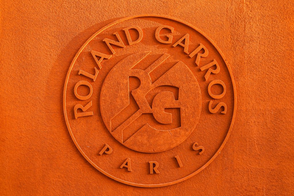 The Roland Garros Paris logo is embossed on an orange clay background, featuring the letters 