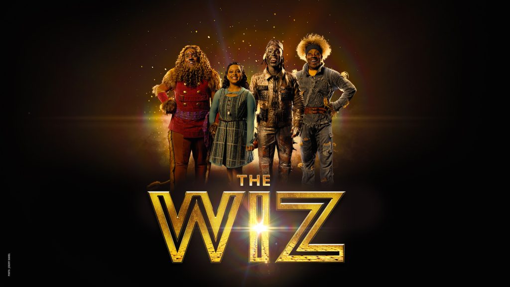 Four smiling characters in colorful costumes stand together against a dark, glowing background. Text below them reads 